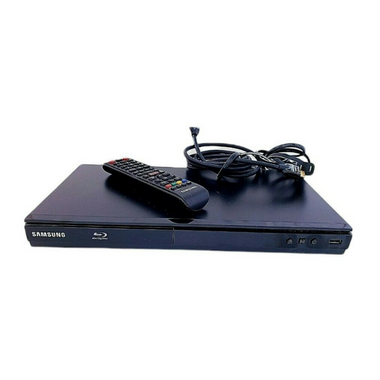 Black bluray player shown from above with remote and cables lying on top.